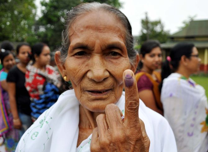 A woman shows her ink-marked finger after casting her vote during the first phase of Assam state Assembly election at a polling station at Amguri, in Sibsager Deistic the northeastern state of Assam, Monday, April 3, 2016. PHOTO- REBA KUMAR BORAH.